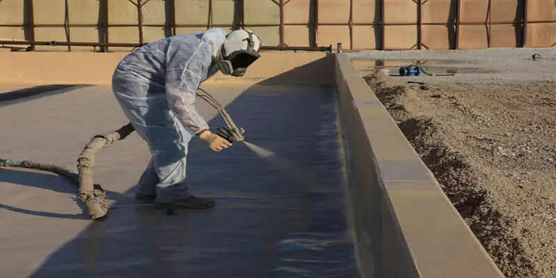 Applicator spraying a containment trench